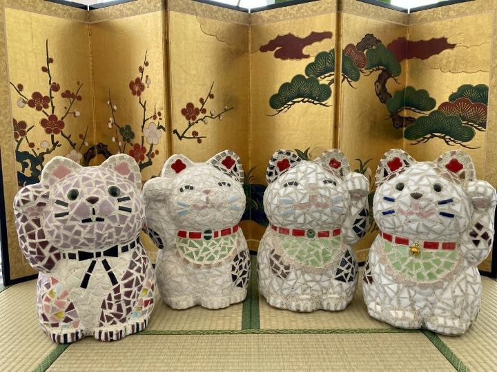 金屏風の前に並んだ招き猫